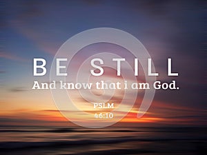 `Be still. And know that I am God.` Bible verse Psalm 46:10 on colorful sunset sunrise sky clouds background over the sea horizon.