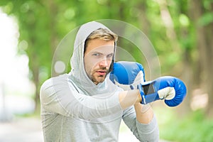 Be strong. man in boxing gloves punching. Sport and sportswear fashion. boxer man in hood. ready to fight. knockout and