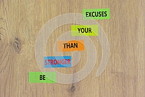 Be stronger symbol. Concept words Be stronger than your excuses on colored paper on a beautiful wooden table wooden background.