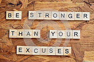 be stronger than your excuses text on wooden square, motivation quotes.