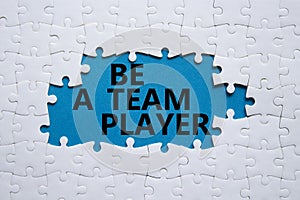 Be a team player symbol. Concept words Be a team player on white puzzle. Beautiful blue background. Business and Be a team player