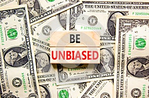 Be unbiased symbol. Concept words Be unbiased on wooden block. Beautiful background from dollar bills. Dollar bills. Business