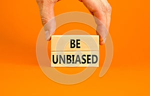 Be unbiased symbol. Concept words Be unbiased on wooden block. Beautiful orange table orange background. Businessman hand.