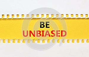 Be unbiased symbol. Concept words Be unbiased on yellow paper. Beautiful yellow table white background. Business psychology be