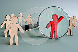 Be unique concept. Talent management with magnifying glass and figurines.