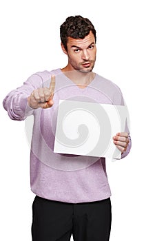 Be warned...A handsome man holding a blank placard and signalling a warning with his index finger.