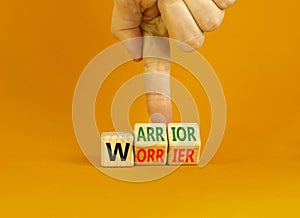 Be warrior not worrier symbol. Concept words Warrior and Worrier on wooden cubes. Businessman hand. Beautiful orange table orange