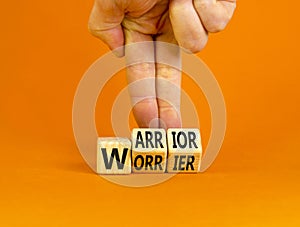Be warrior not worrier symbol. Concept words Warrior and Worrier on wooden cubes. Businessman hand. Beautiful orange table orange