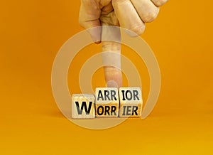Be warrior not worrier symbol. Concept words Warrior and Worrier on wooden cubes. Businessman hand. Beautiful orange table orange