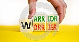 Be warrior not worrier symbol. Concept words Warrior and Worrier on wooden cubes. Businessman hand. Beautiful yellow table white