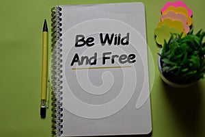 Be Wild and Free write on a book isolated on office desk