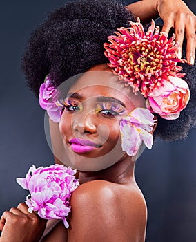 Be your own kind of beautiful. Studio shot of a beautiful young woman posing with flowers in her hair.