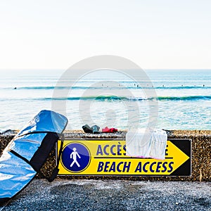 Beach access sign and surfboard