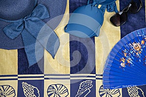 Beach accessories on bath towel - hat, bikini, sunglasses, and fan