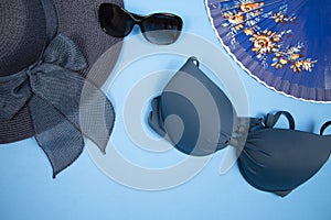 Beach accessories on blue background- hat, bikini, sunglasses and fan