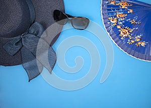 Beach accessories on blue background - hat, sunglasses and fan with space for text, logo