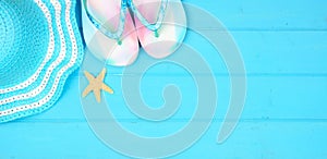 Summer vacation beach accessories banner on a blue wood background with copy space