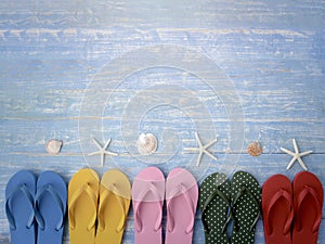 Beach accessories on blue wooden plank  summer holiday on the beach concept  colorful sandals with seashell and starfish