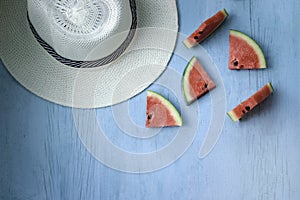 Beach accessories on blue wooden plank  summer holiday on the beach concept  hat and fresh red water melon slicered on wood