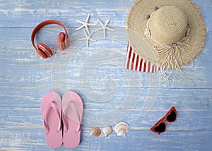 Beach accessories on blue wooden plank  summer holiday on the beach concept  hat  red headphones seashell  starfish  towel and