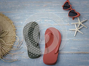 Beach accessories on blue wooden plank summer holiday on the beach concept hat red sunglasses seashell and starfish.