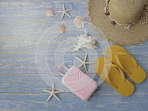 Beach accessories on blue wooden plank  summer holiday on the beach concept  hat  seashell  starfish  laggage and slippers