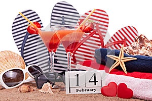 Beach accessories, calendar with date 14 february and two glasses with cocktail. Beach holidays. Valentine`s Day