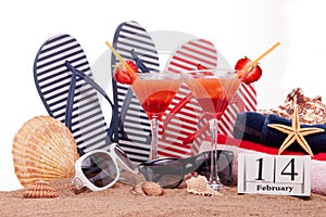 Beach accessories, calendar with date 14 february and two glasses with cocktail. Beach holidays. Valentine`s Day