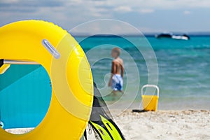 Beach accessories and chair on beach and child playing