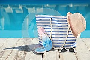 Beach accessories on deck near outdoor swimming pool, space for text