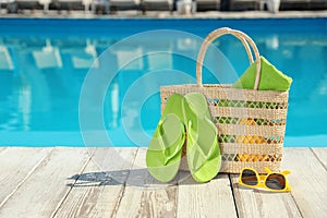 Beach accessories on  deck near outdoor swimming pool, space for text