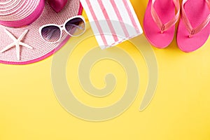 Beach accessories flip flop, sunglasses, starfish, beach hat and sea shell on yellow pastel background for summer holiday and