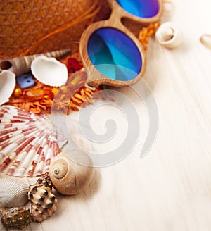 Beach accessories glasses hat cockleshells on wood deck