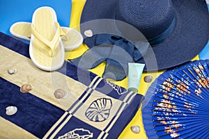 Beach accessories on pastel backgrounds - sunglasses, hat, towel, flip-flops, fan and sunscreen