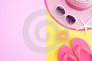 Beach accessories retro film camera, sunglasses, flip flop starfish beach hat and sea shell on pink and yellow background for