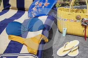 Beach accessories, swimming pool accessories in the home garden on printed concrete, bag, towel, sun lounger