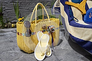 Beach accessories, swimming pool accessories in the home garden on printed concrete, bag, towel, sun lounger