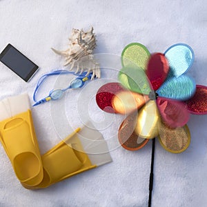 Beach accessories on a white towel with children`s turntable