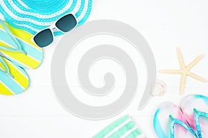 Frame of summer vacation beach accessories on a white wood background with copy space