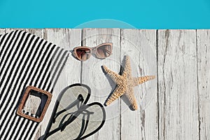 Beach accessories on wooden deck near outdoor swimming pool. Space for text