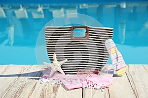 Beach accessories on wooden deck near swimming pool