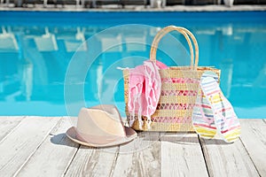 Beach accessories on wooden deck near swimming pool