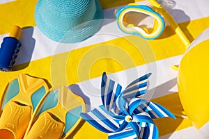 Beach accessories on yellow striped towel