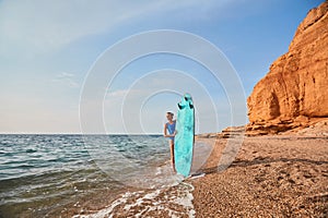 Beach, adventure time and summer holiday concept. Cute woman with surfboard on nature landscape background. Copy space