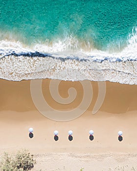 Beach aerial view of umbrellas, waves, blues ocean and relaxing vibes