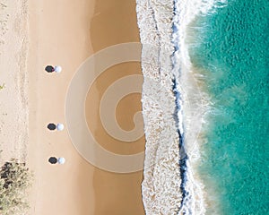 Beach aerial view of umbrellas, waves, blues ocean and relaxing vibes