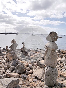 Beach art piles of rocks looking out over the bay at Playa Blanca Lanzarote