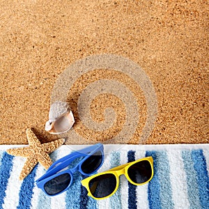 Beach background border sunglasses, towel, starfish, seashell square format sand copy space