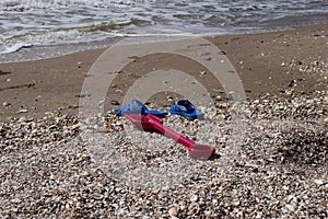 Beach background with flip flop and plastic spade.