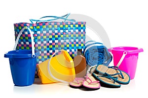 Beach bag with buckets, towel, flip-flops and suntan lotion